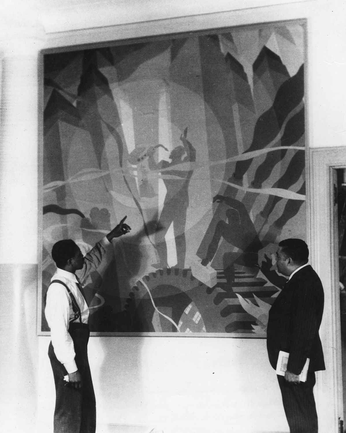 Aaron Douglas (left) discusses his new painting “Song of the Towers” in 1934 with Schomburg Collection curator Arturo Alfonso Schomburg. Photo Source: Photographs and Prints Division, Schomburg Center