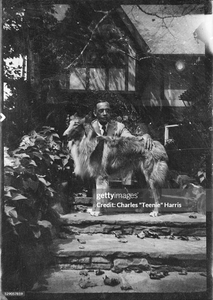 A black and white photograph of Vann, pictured with his dog, on the steps of his home in the 1930s. Photo Source: Charles “Teenie” Harris, Getty Images