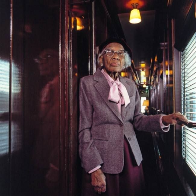 Tucker, depicted later in life, wearing a suit while standing in a sleeping car of a train. Photo Source: Black Our Story on tumblr.