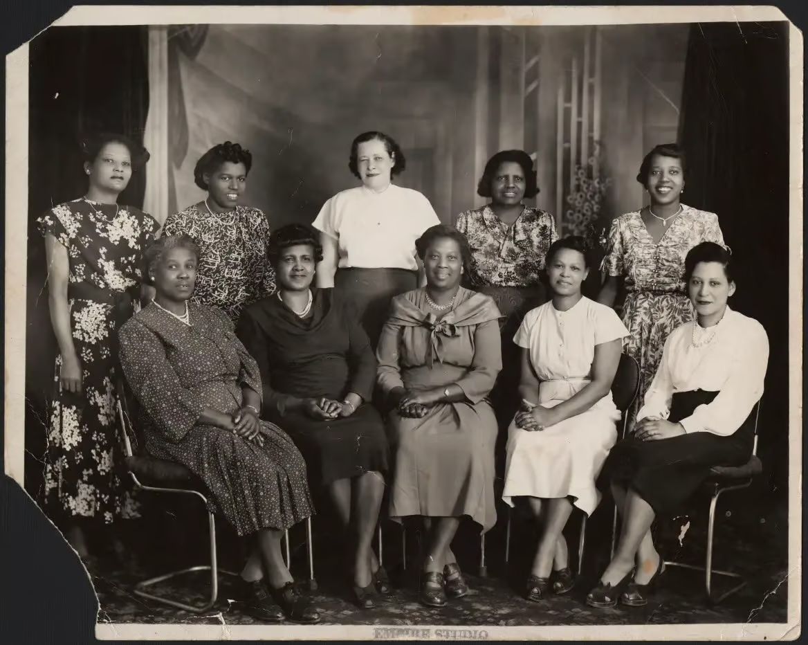 Photo of the members of the Ladies Auxiliary, Toronto Pullman Division, Brotherhood of Sleeping Car Porters, of ten women in fine dress seated in a portrait setting. Photo Source: Library and Archives