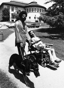 A black and white photograph of Galloway, left, with his guide dog standing next to Ed Roberts (right). Photo Source: The Center for Learning Equity