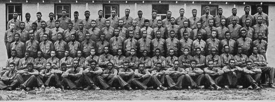 A black and white photograph of about 100 members of an all-Black CCC Company C-3790, Camp P-71, located in Arkansas, all in uniform and posing like a class photo. Photo Source: Living New Deal