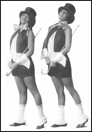 A black and white photograph of Emma Chambers Maitland posing with Aurelia Wheeldin as dancers for the performance “Tea For Two Girls.” Photo Credit: Cathy Van Ingen